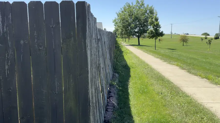 Example of leaning and uneven fence sections along pathway