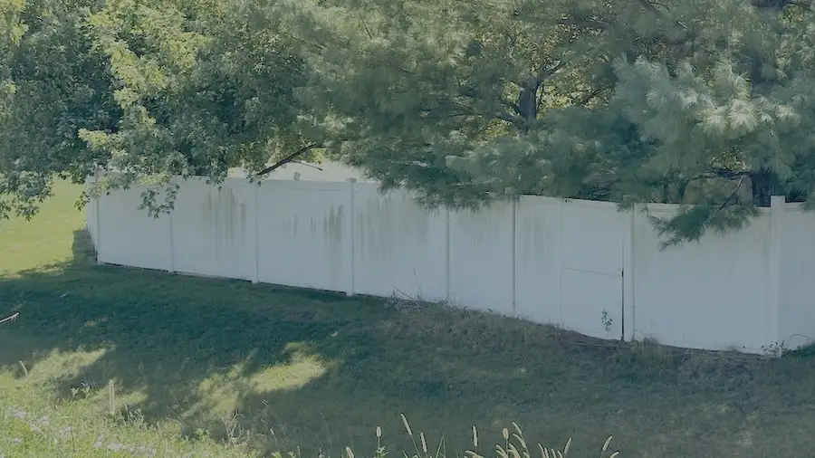 Example of visible discoloration and mildew stains on white vinyl fence