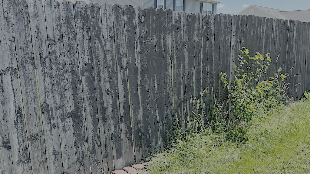 Example of fading and peeling paint on wooden fence
